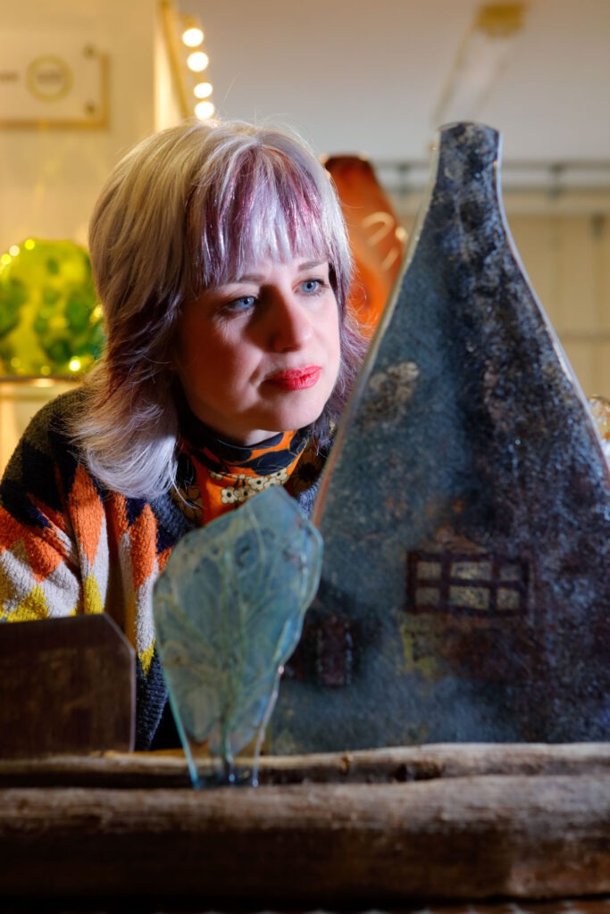 award winning Glass artist Terri Malcolm inspects one of her latest artworks which has been created using recycled glass and mixed media all of which is of a recycled nature