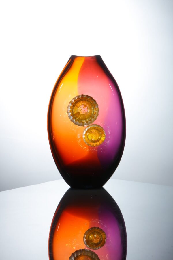 a single vase glows beautifully with a warm energy due to the tones of red and amethyst in this piece of glassart by Allister Malcom for sale on the website
