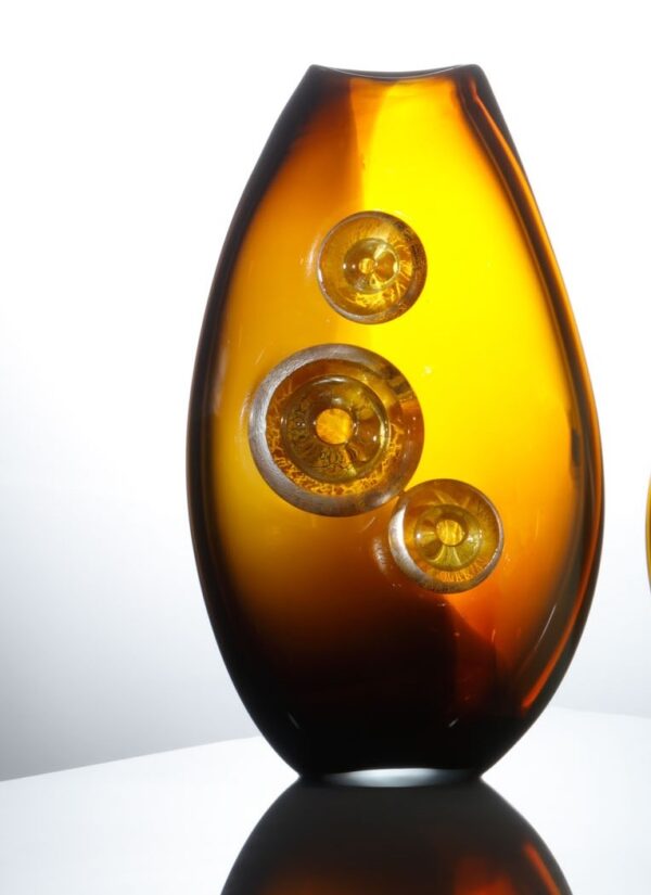 An amber gold vase with silvery details mounted to the surface create a visually unique work of glass art which is for sale in the website